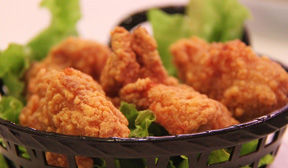 Chicken fingers on a bed of green lettuce in a lattice basket.